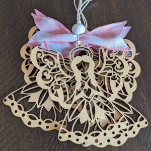 Set of two laser cut wooden angel ornaments with detailed scrollwork wings, finished with a pink and white bow and white bead, shown on a wooden surface.