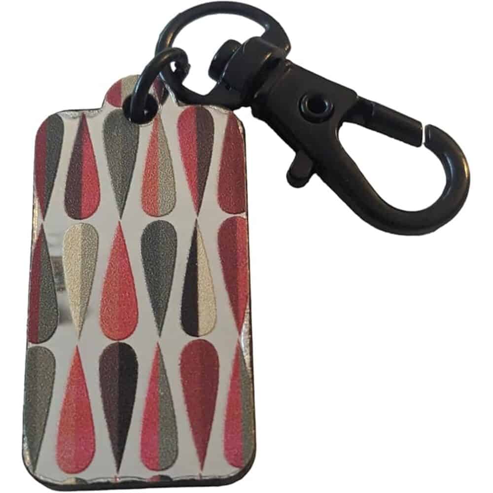 Colorful patterned bag with a black cling clip and lanyard, stylish accessory by Yellow Lab Creations.